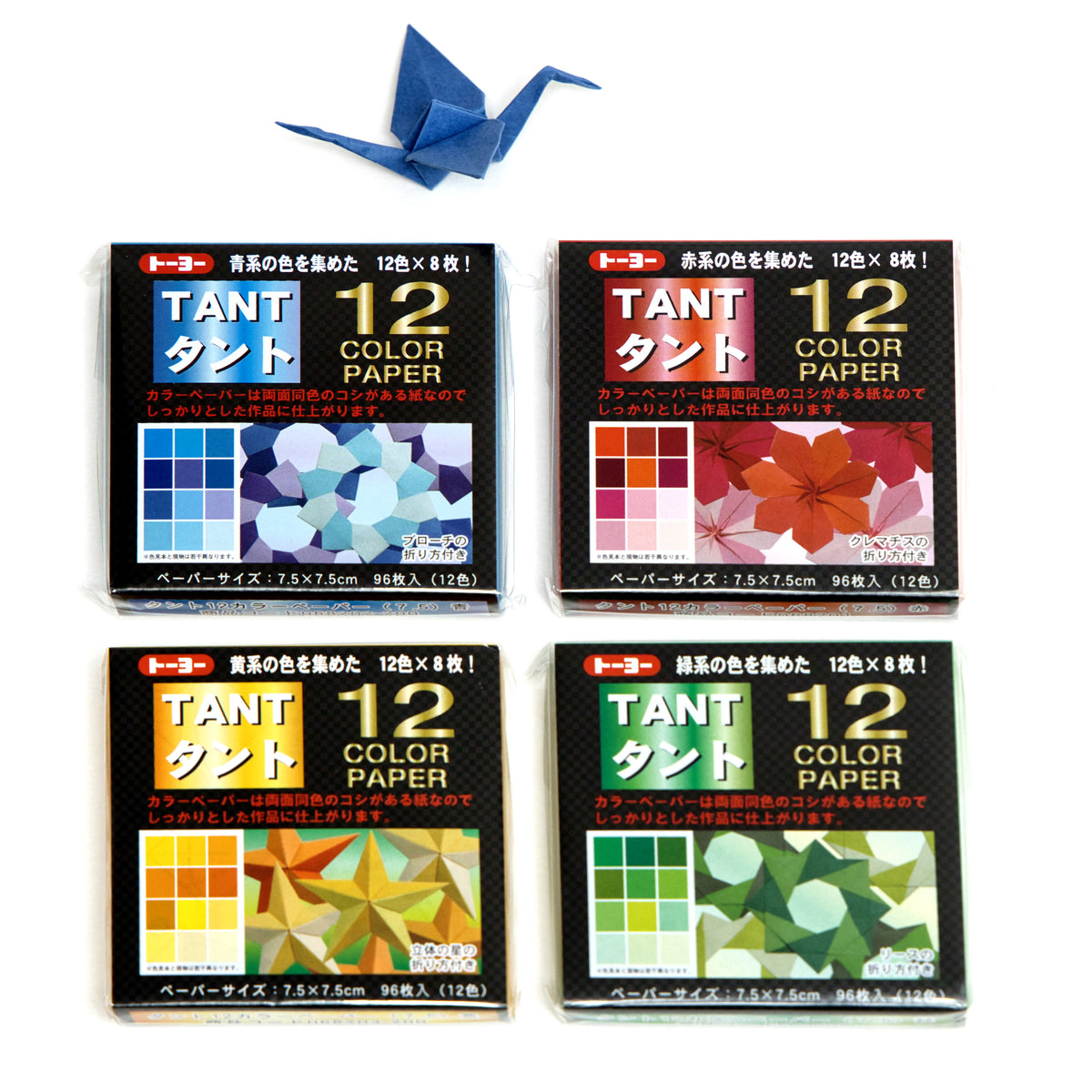 Four packs of Japanese TANT (origami) color paper arranged in a 2x2 grid, with a single blue origami crane model displayed above them on a plain white background.
