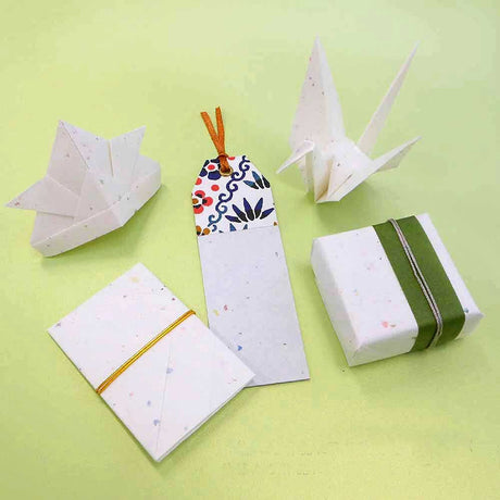 Origami cranes and gift-wrapped boxes on a green background